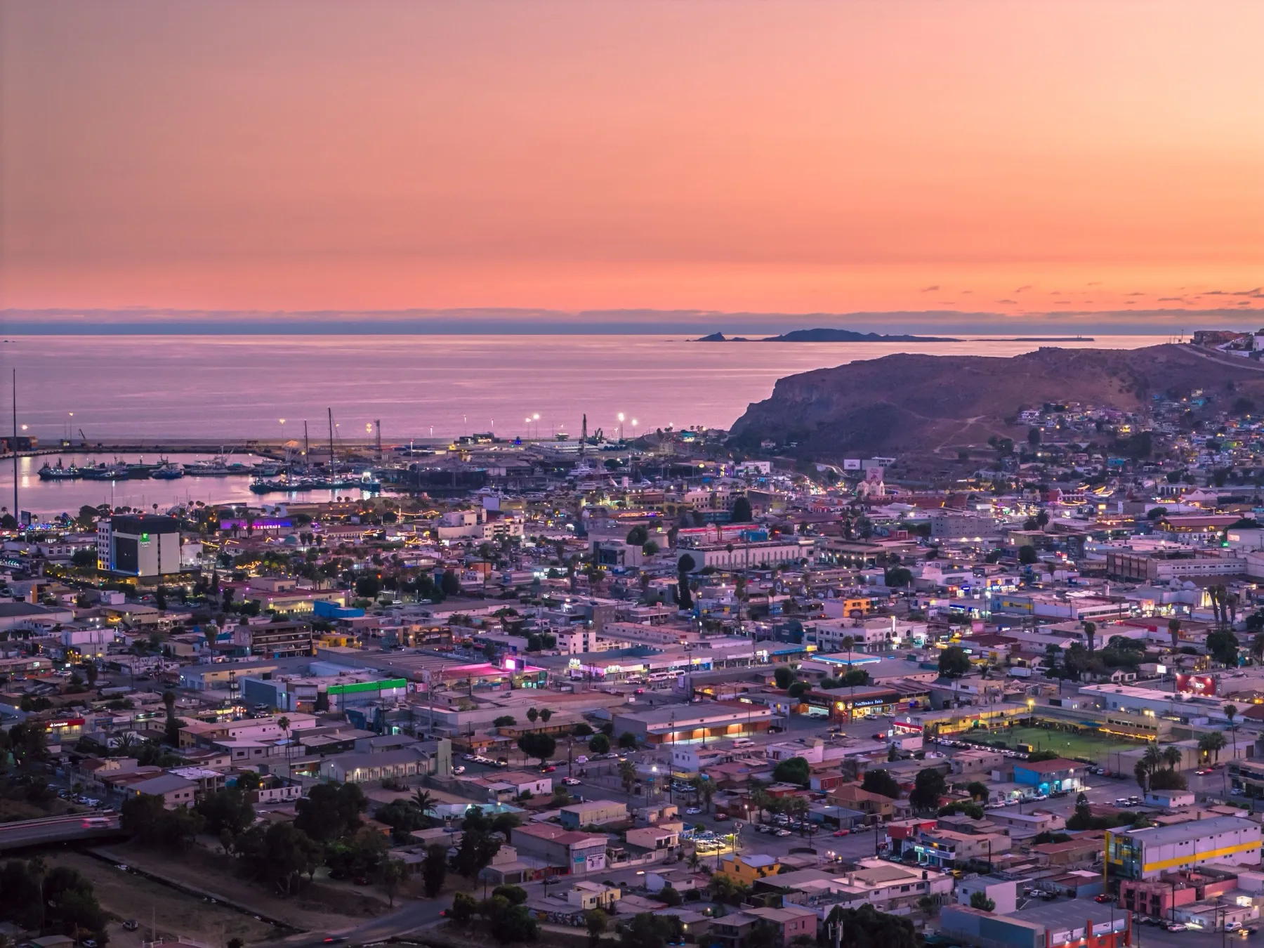 Baja California coastline with the highway running between dry hills and the Pacific Ocean at the edge of the frame