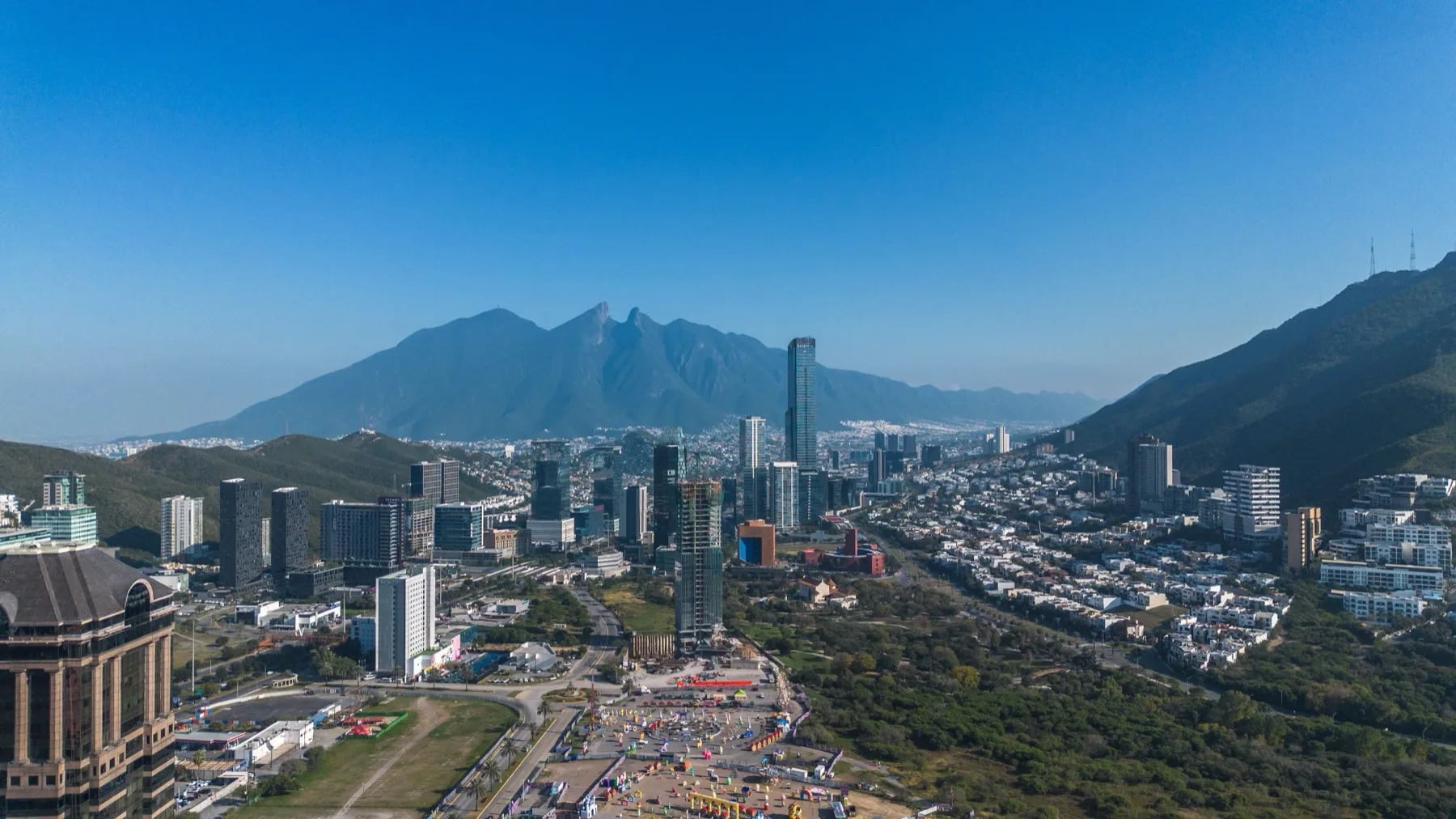 Monterrey seen from above with dense towers and the Sierra Madre mountain wall closing the valley behind the city