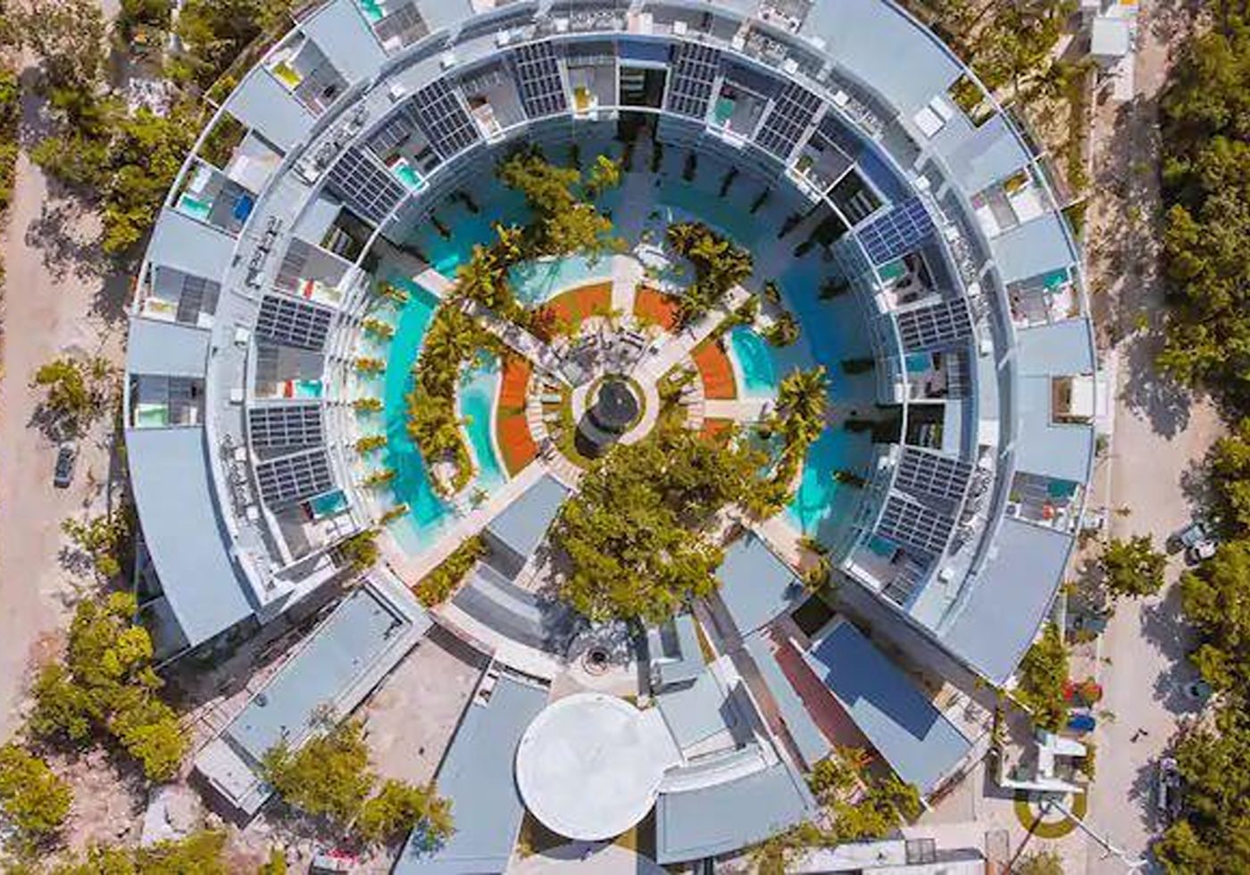 Aerial daytime view of Central Park Lagunas, its pools, courtyard, and the surrounding La Veleta jungle canopy