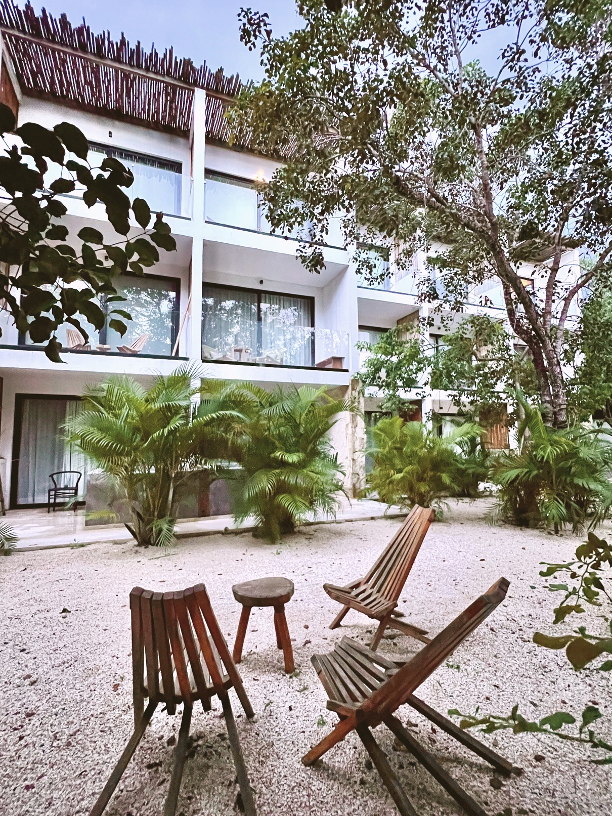 Aerial view of Erena Mindful Apartments, La Veleta, Tulum, showing its rooftop infinity pool and ground-level courtyard pool
