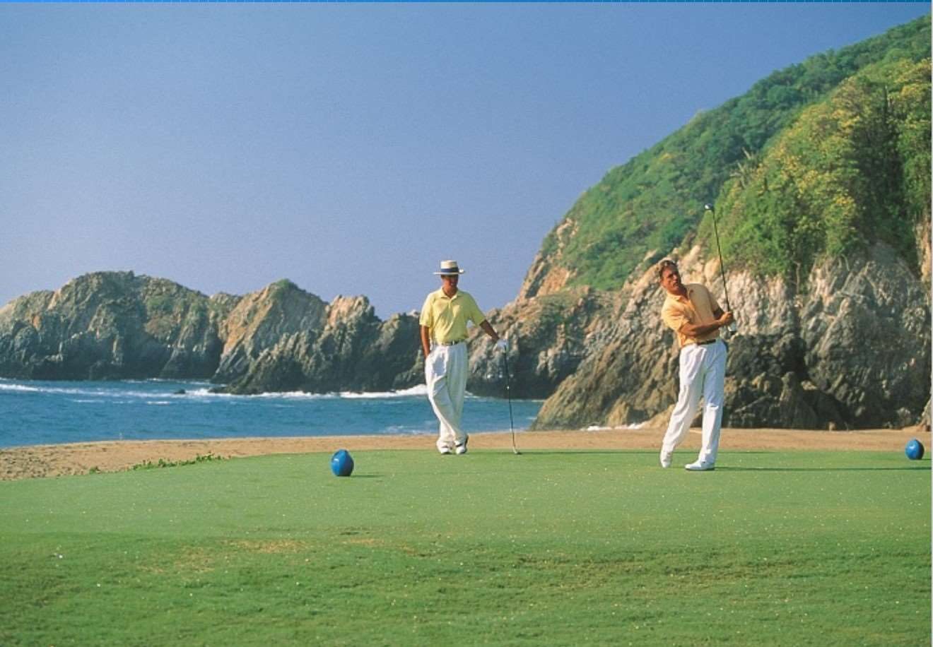 Golfers on an oceanside hole below the cliffs