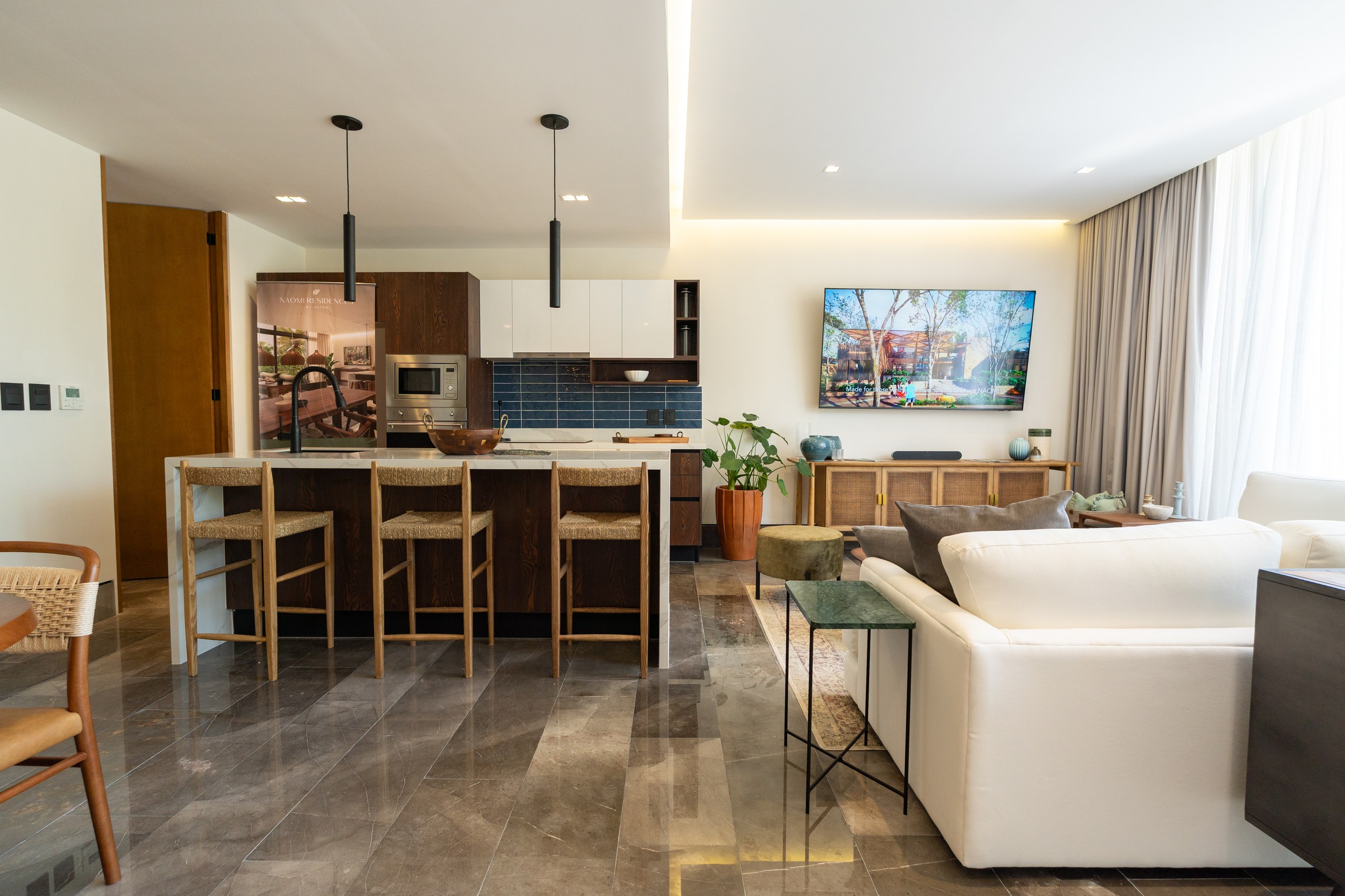Photograph of the furnished sample unit kitchen and living area, daytime