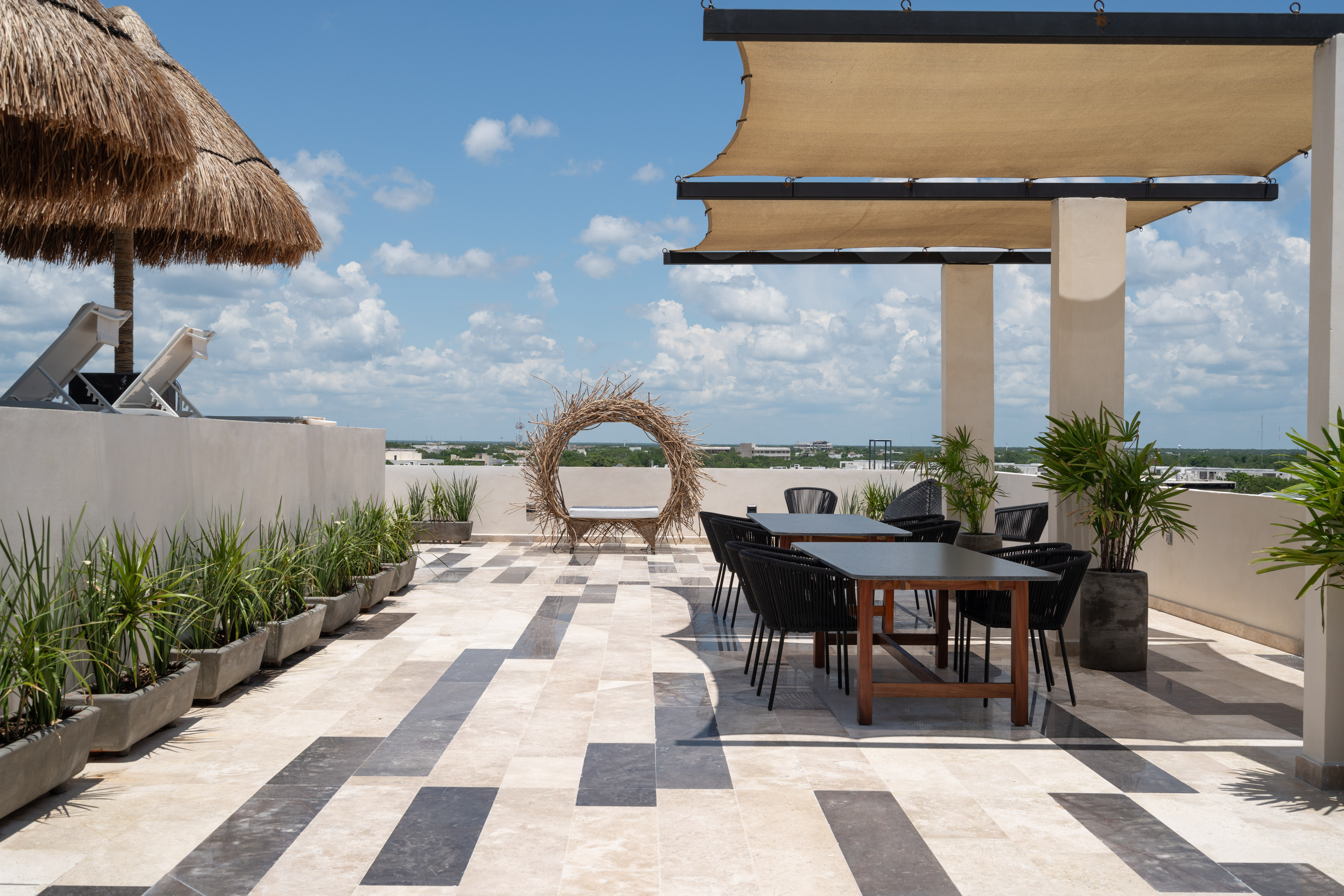 Rooftop lounge and dining area under a woven-branch archway
