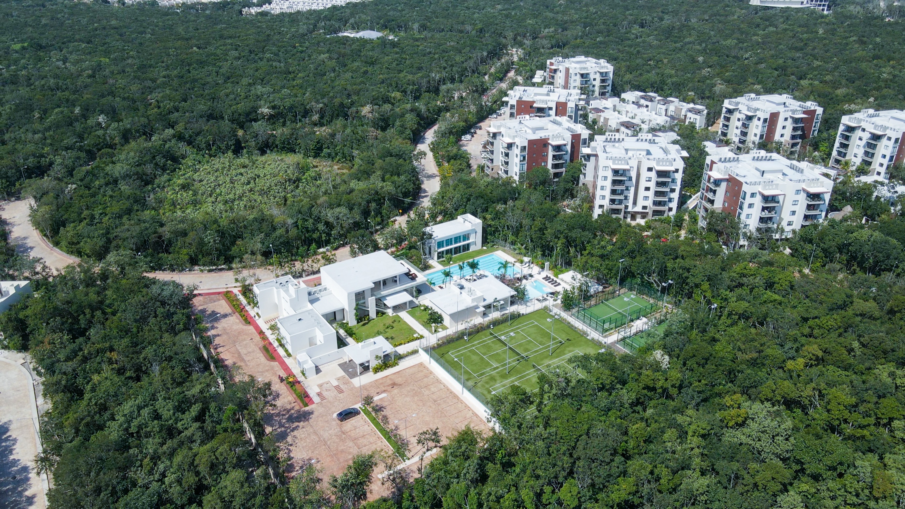 Aerial photograph of the Senderos club house with the apartment blocks of Ciudad Mayakoba behind it