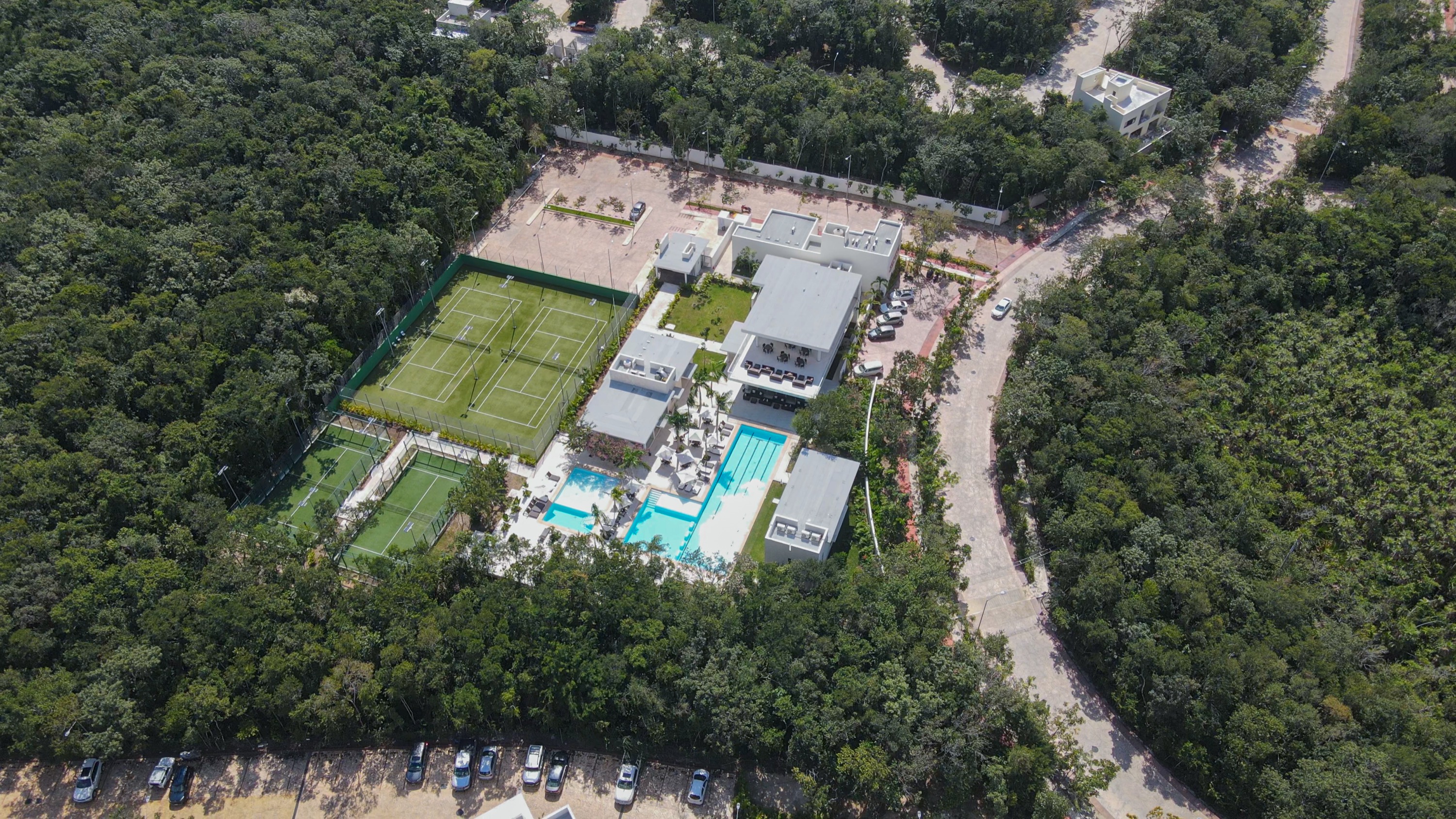 Aerial photograph of the club house complex with one finished house standing alone in the jungle beyond