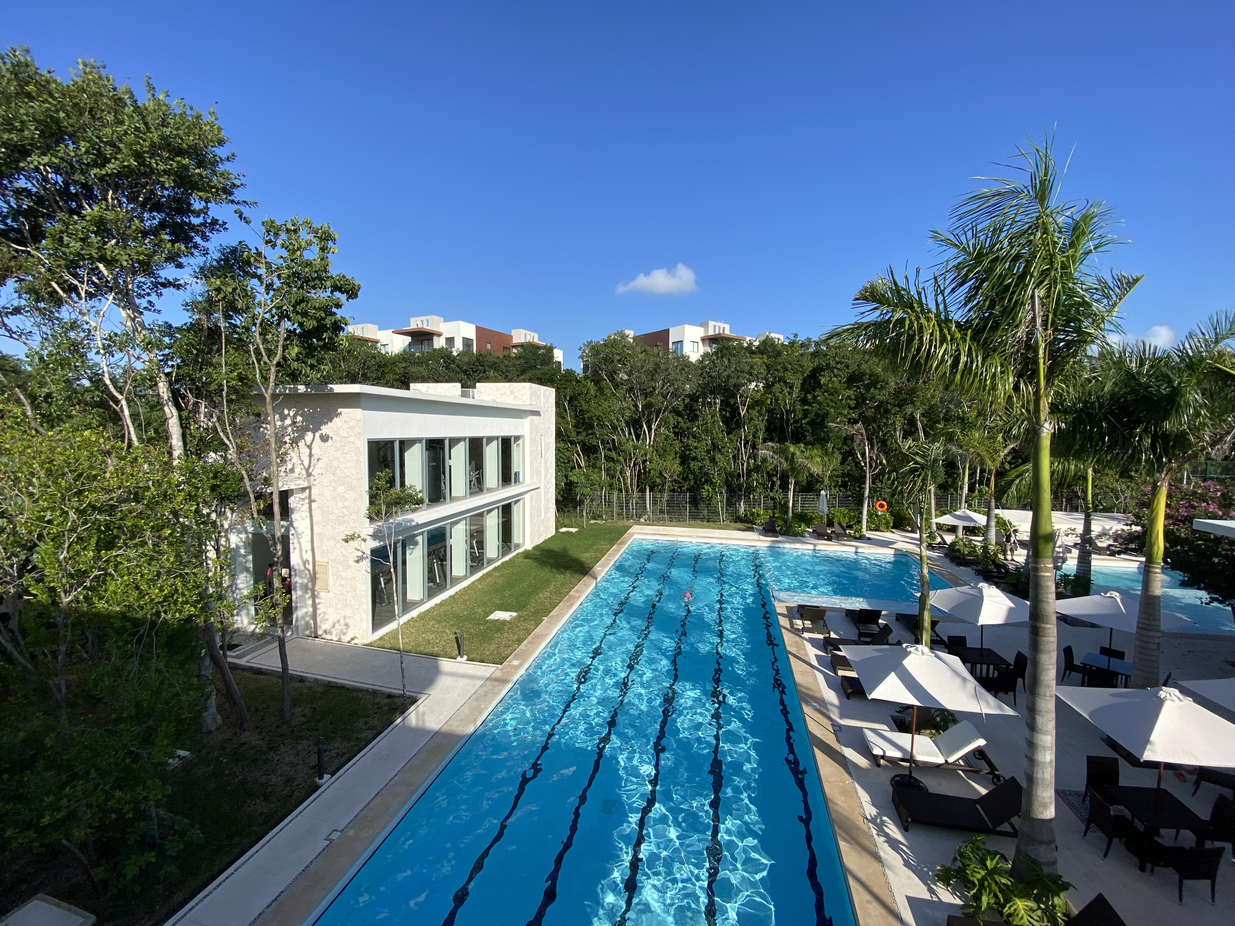Photograph of the lap pool and gym building at the Senderos club house, Ciudad Mayakoba