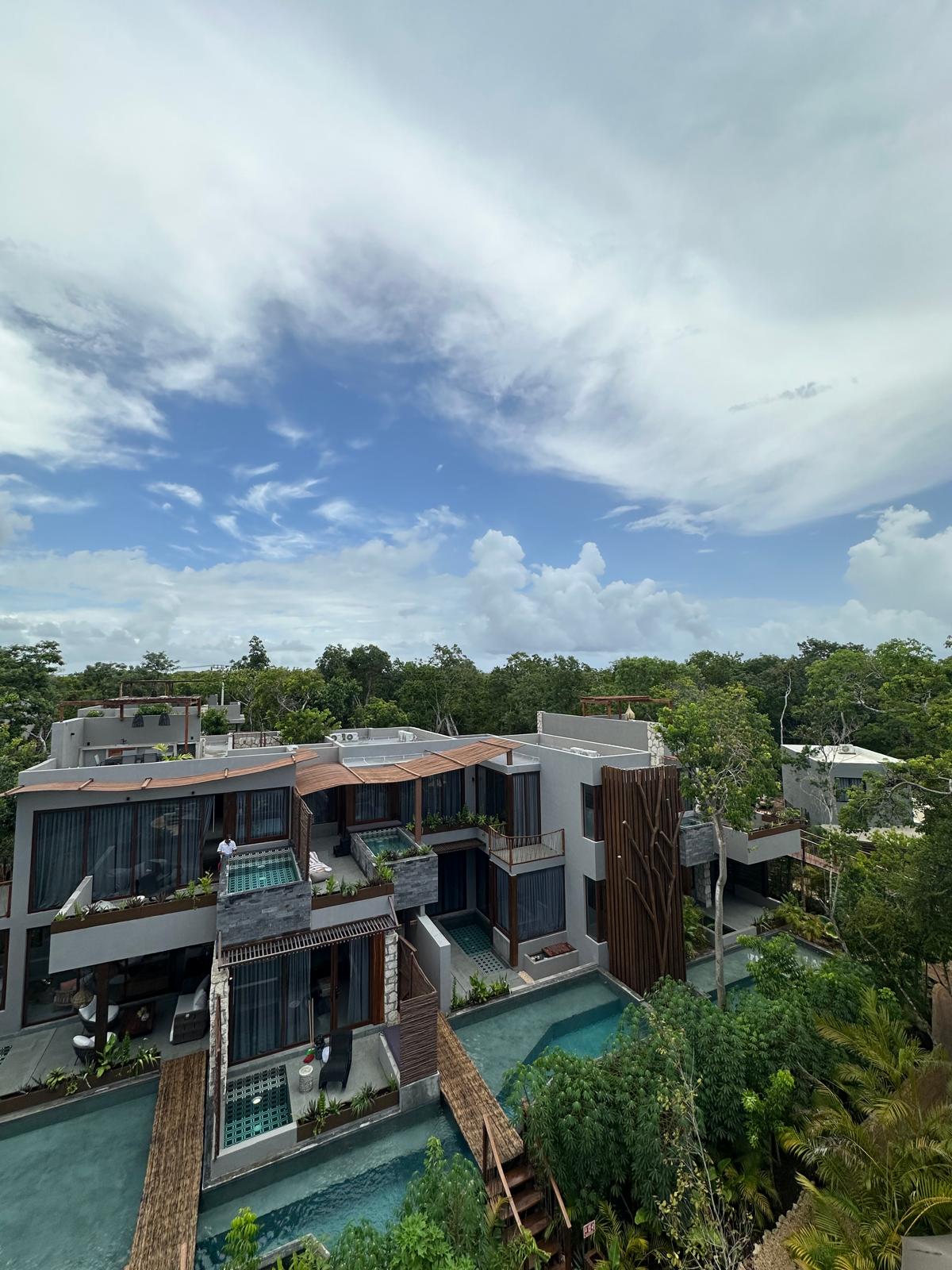 Wider view of B2-101 from an elevated walkway, showing the rooftop terrace structure and the jungle canopy around it