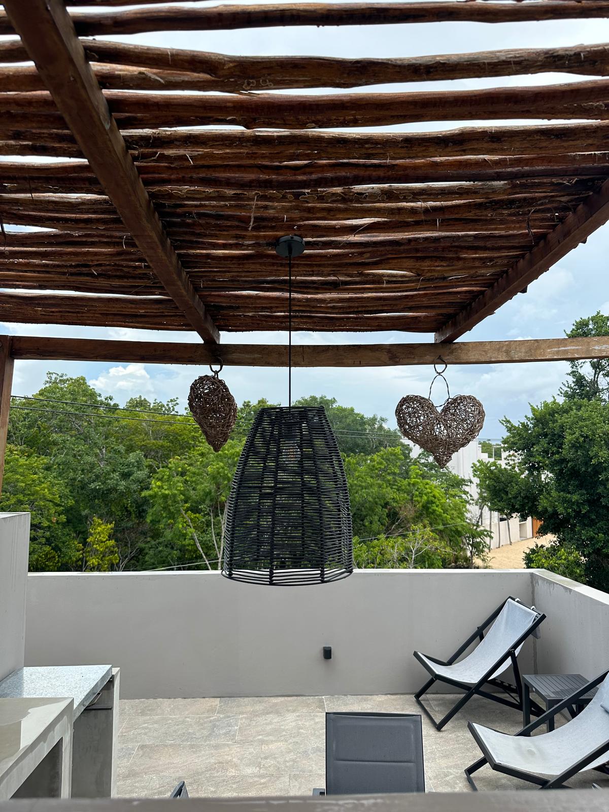 Rooftop lounge chairs and pendant lighting on B2-101’s private roof terrace