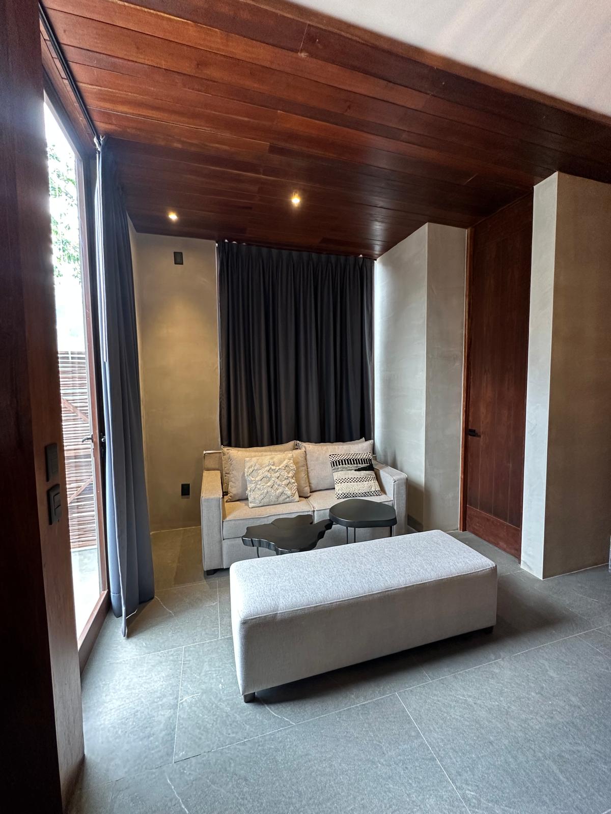 Living room of Siwa Tulum B2-101 with curtained glass doors opening to the terrace