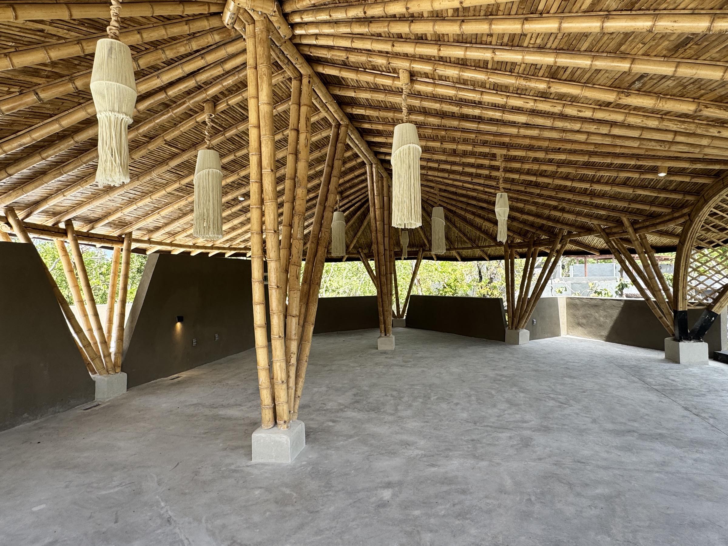 Interior of the bamboo yoga pavilion at Siwá Élevé, arched opening onto the jungle