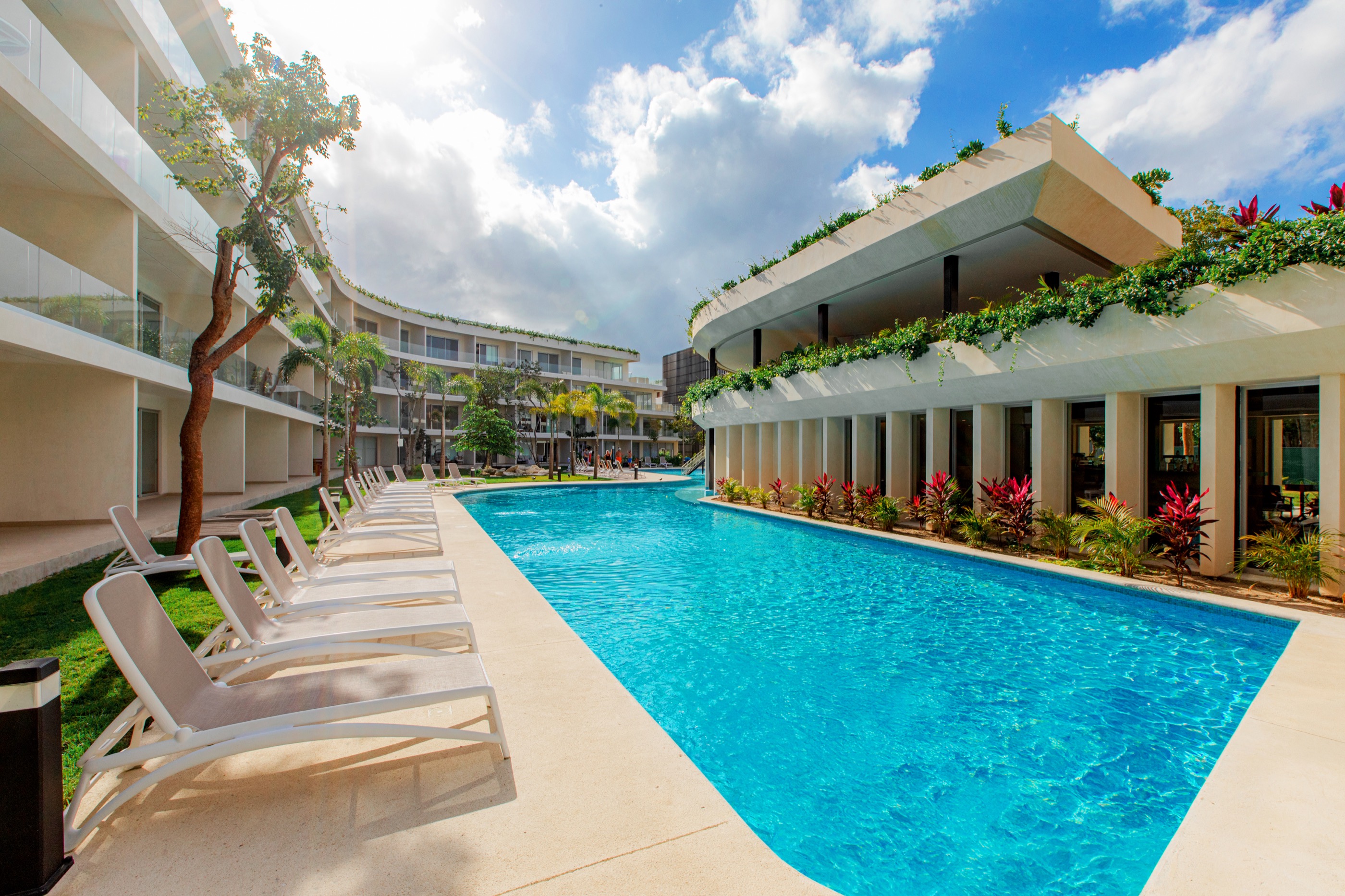Lap pool and planted terraces between two finished residential wings at The Leaf Condos Playacar, Playa del Carmen
