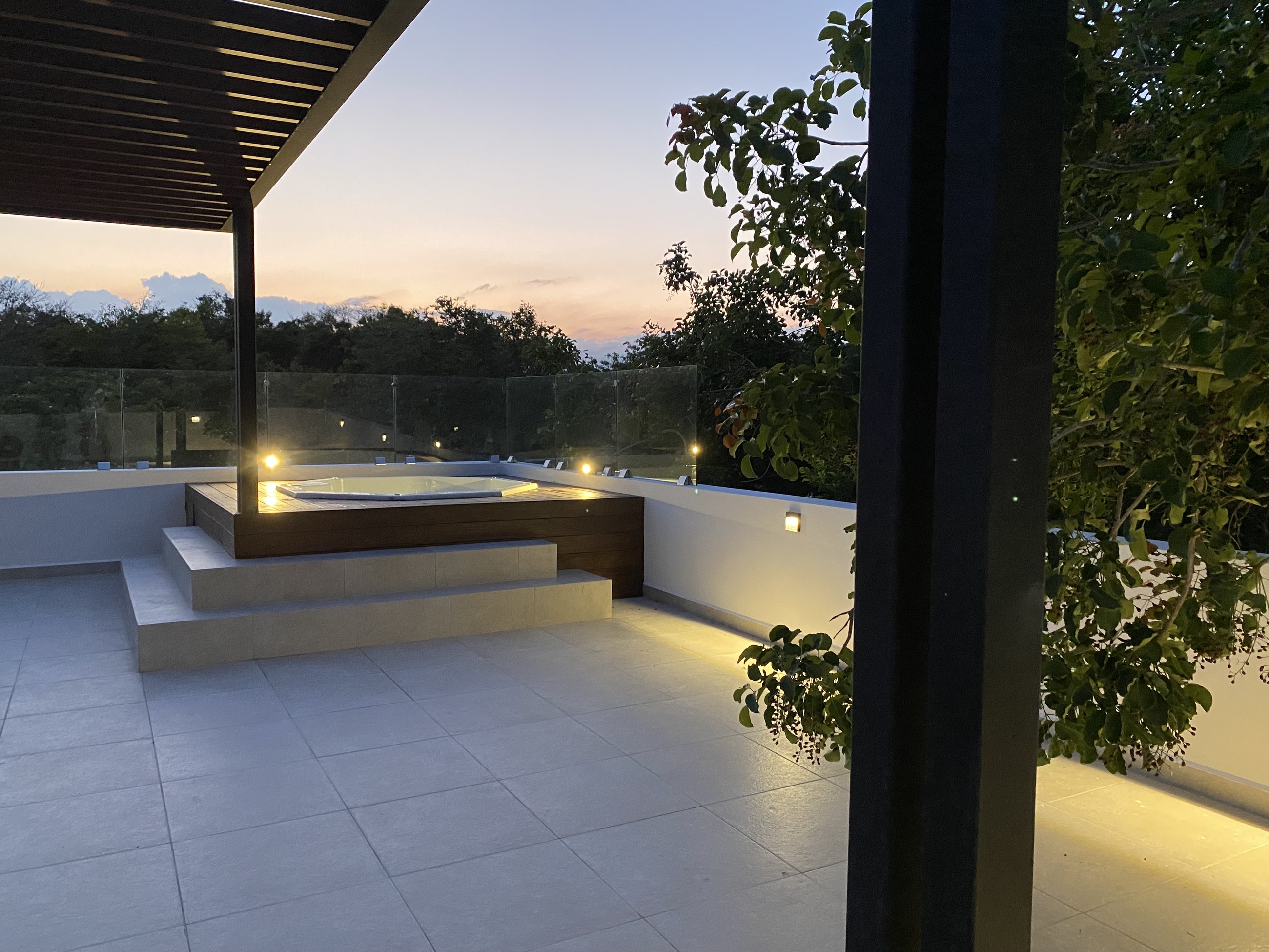 Rooftop terrace of the finished Villa Tortuga, Villas Aliada, at dusk with jungle behind