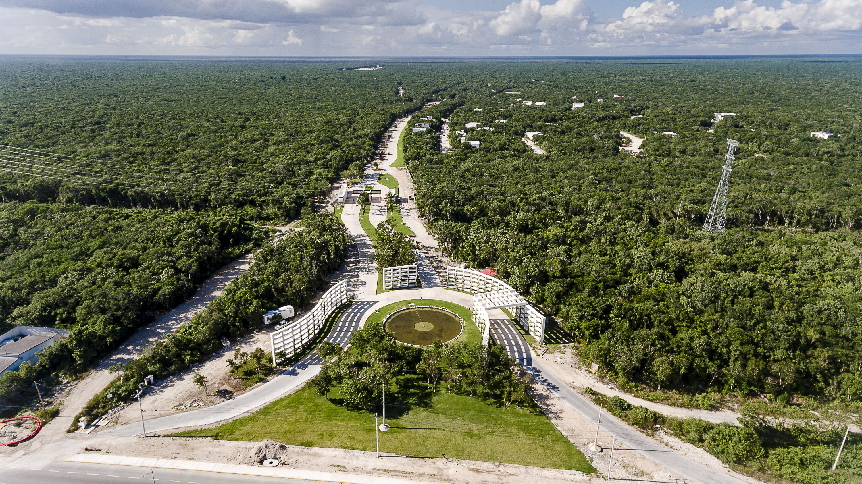Aerial photograph of the paved access road and roundabout entrance to Xpuha Beach Residential Resort