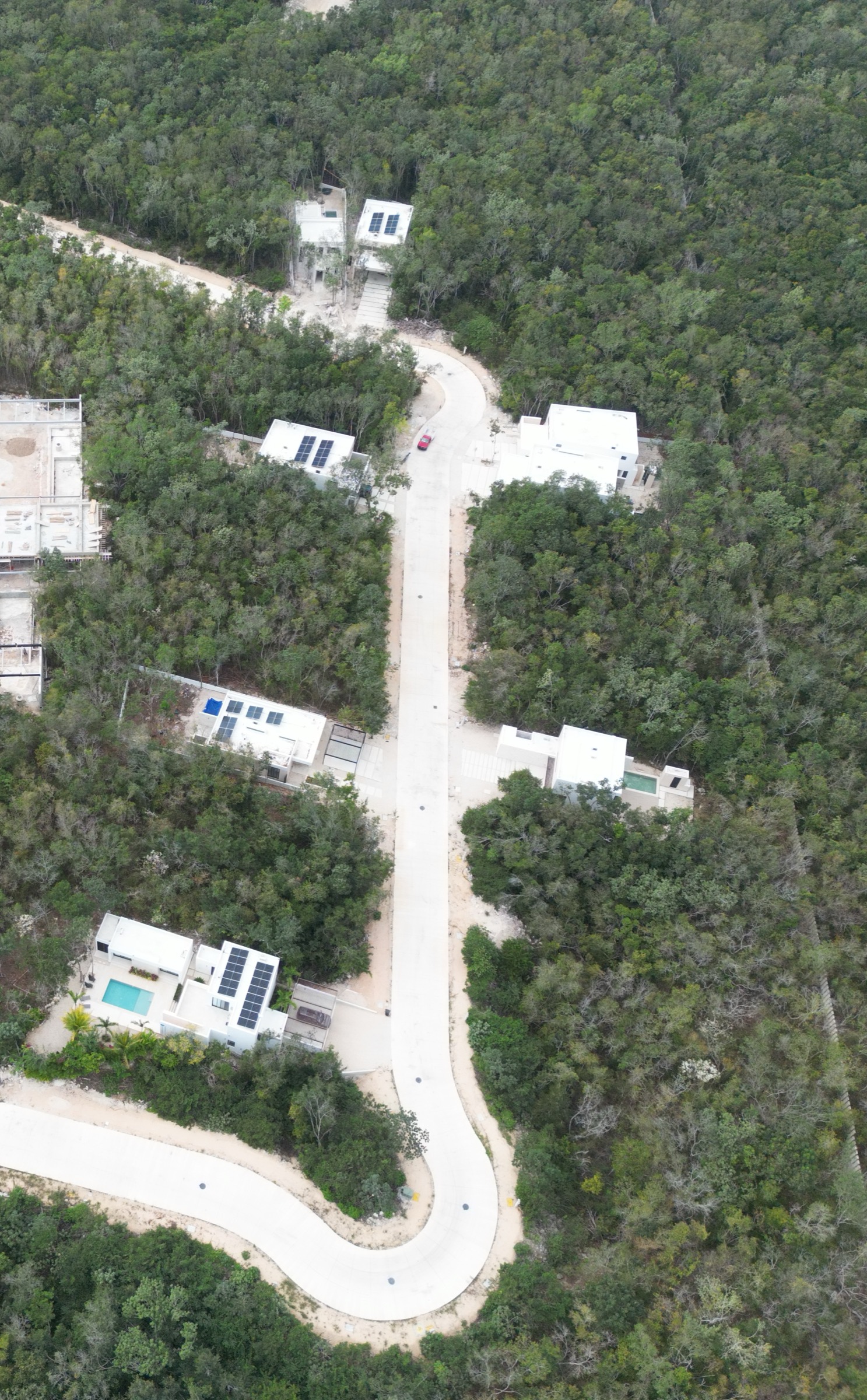 Aerial photograph of the access road running through dense jungle toward the coast at Xpuha Beach Residential Resort