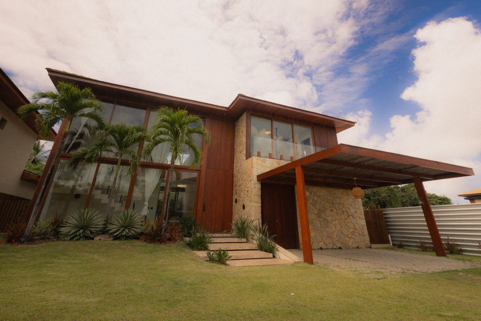 Tropical house in wood and stone with palms